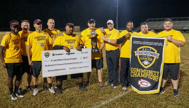The Chopticon coaching staff proudly pose with the 2017 Touchdowns Against Cancer National Champions trophy, Community Champions banner and the oversized check presented to St. Jude Children's Research Hospital.