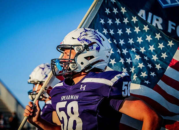 Connor Holton of Spearman (Texas) carries the American flag on to the field before a home game against Childress.