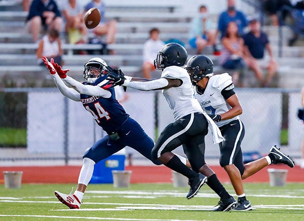 Receiver Jahlan Paul of Westminster Academy (Fla.) stretches to make a touchdown catch in front of two St. John Paul II Academy defenders.