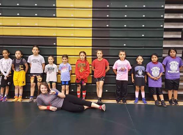 Coaching and refereeing younger wrestlers is one way Logan contributes to her community.