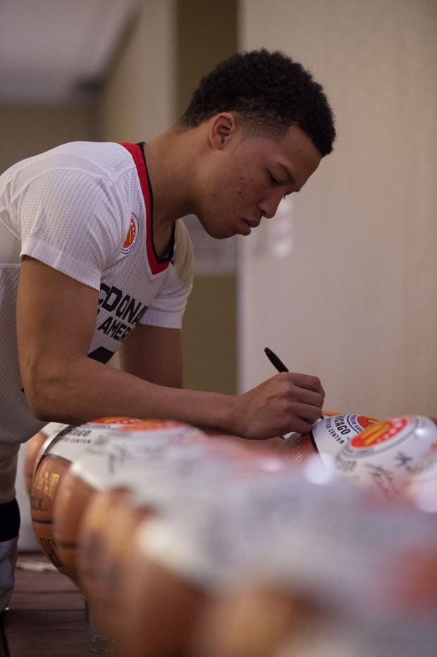 Local lad Jalen Brunson of Stevenson (Lincolnshire, Ill.) signs some basketballs for charities.