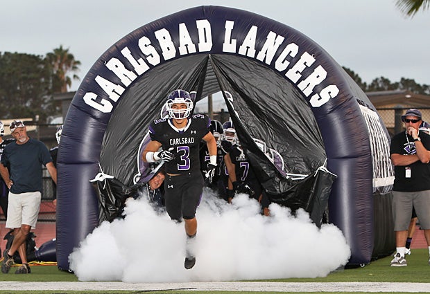 Troy Cassidy leads Carlsbad (Calif.) onto the field in their game against Lincoln (San Diego).