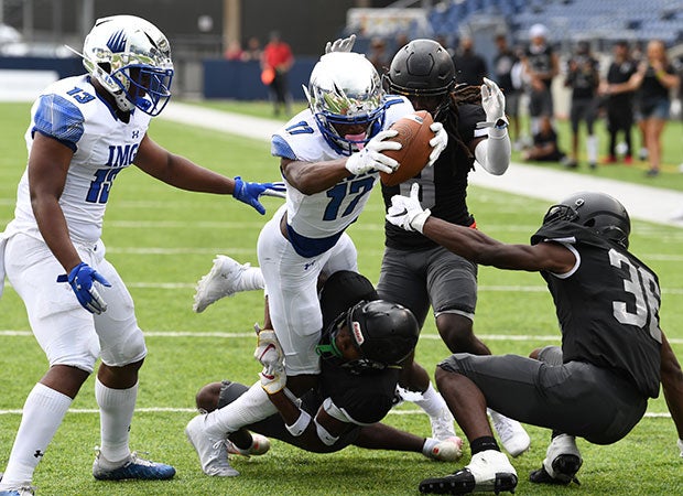 Receiver Carnell Tate dives into the end zone for one of his two touchdowns for IMG.