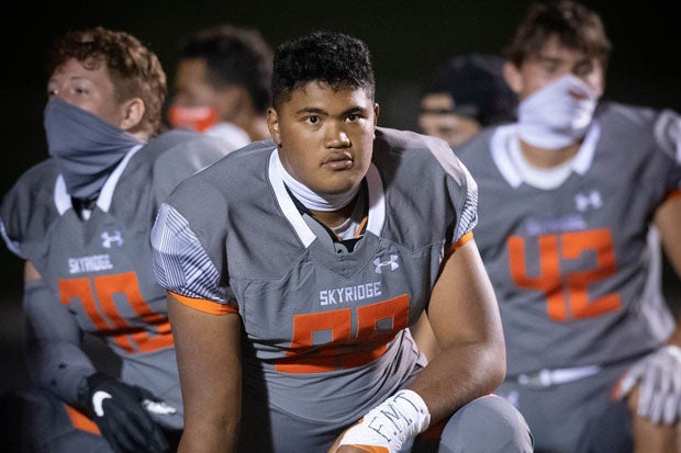 A Skyridge (Lehi, Utah) player is flanked by a pair of masked teammates.