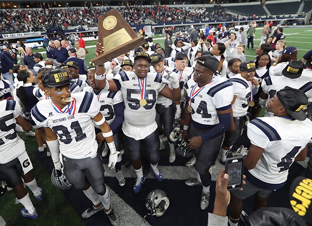 Morris Joseph (holding trophy) and his West Orange-Stark teammates celebrate their victory in the UIL 4A Division II championship game at AT&T Stadium on Friday afternoon.