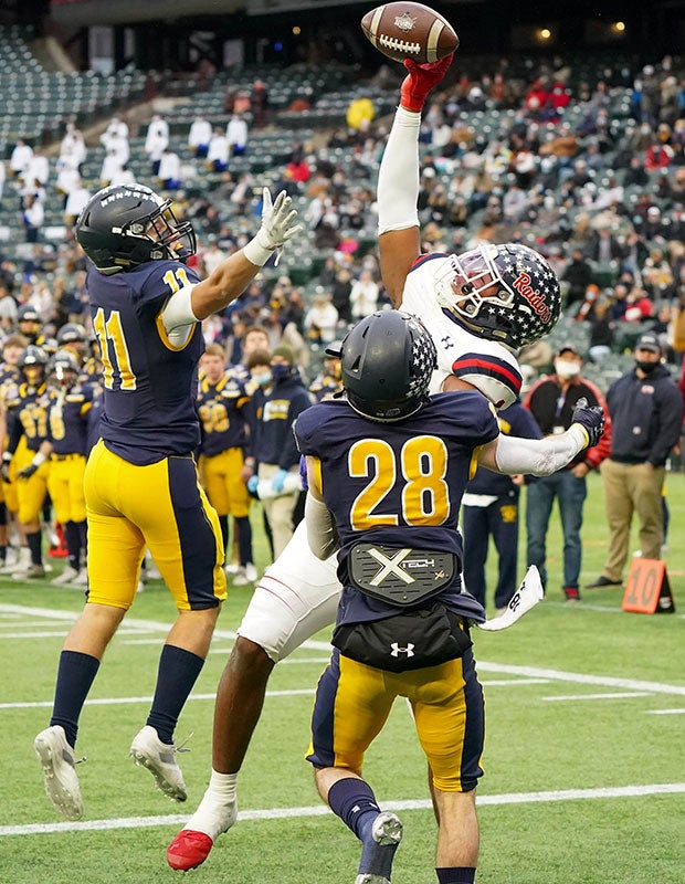 Denton Ryan (Texas) receiver Ja'tavion Sanders makes a stellar one-handed touchdown catch above two Highland Park defenders in the UIL 5A Division 2 quarterfinal at Globe Life Park in Arlington.