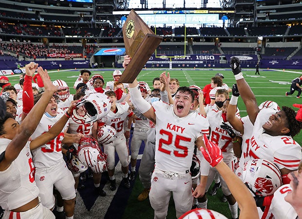 Katy (Texas) senior Shepherd Bowling proudly hoists the trophy among his celebrating teammates after winning the UIL 6A Division 2 state championship game over Cedar Hill at AT&T Stadium.