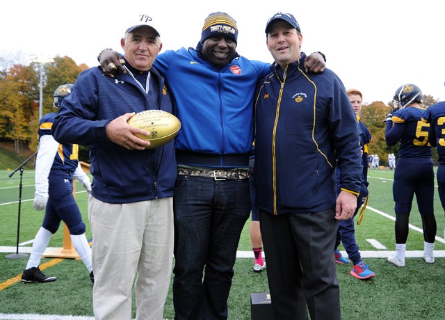 Chukky Okobi is flanked by his former Trinity-Pawling coach, David Coratti, left, and T-P headmaster Bill Taylor. Coratti displays the NFL's commemorative Wilson Golden Ball, symbolic of this season's Golden Anniversary of the Super Bowl and part of the NFL's Super Bowl High School Honor Roll Initiative program.