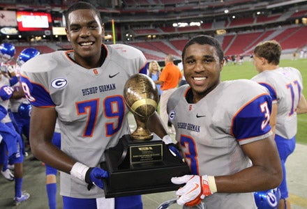 Ronnie Stanley (left) and Shaq Powell pose with trophy after resounding victory.
