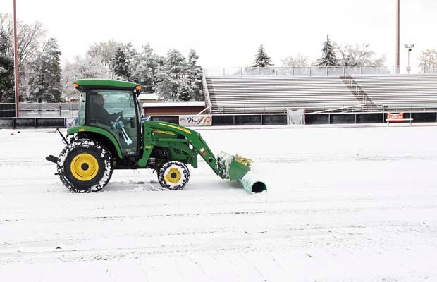 A worker does his best to clear snow from All City Stadium in preparing for two boys soccer playoff games that were scheduled to be held last Thursday afternoon.