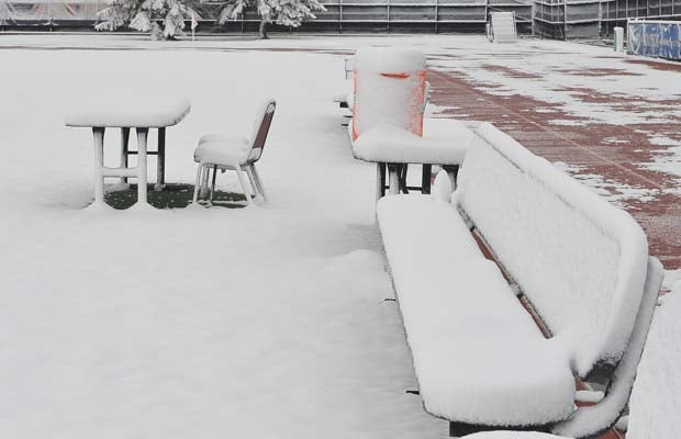 The scorer's table and team benches for two boys soccer playoff games are covered in snow at All City Stadium.