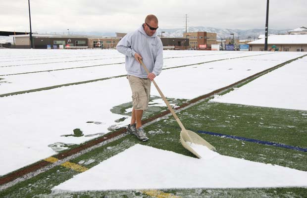 Tony Harpstreith works to clear snow from the end zone at Shea Stadium. 