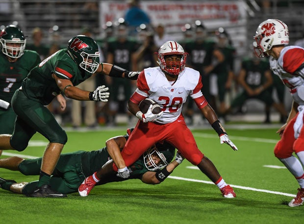 Tacklers from The Woodlands handle a Katy ball carrier as the Highlanders won 26-3.