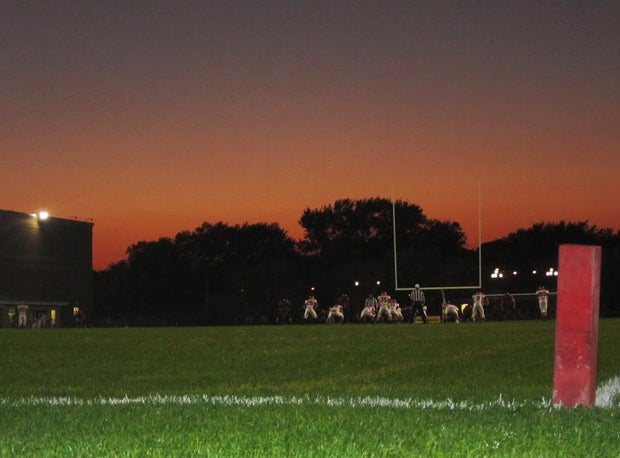Big trees near City Stadium provide a dark background during dusk.