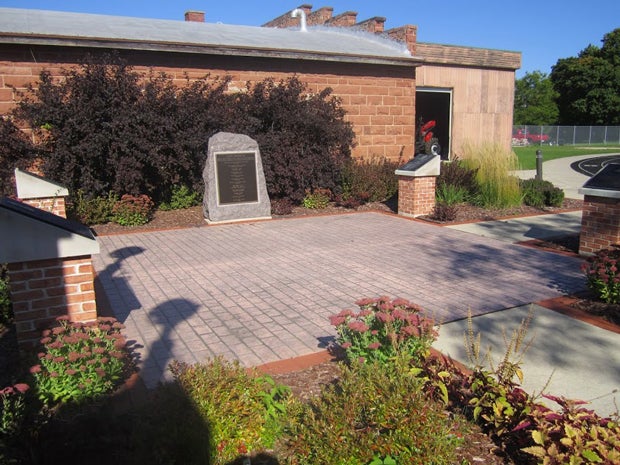 Monument Park hosts plaques honoring the stadium's history, and the building in the background is an equipment shed that used to house gear and uniforms of Packers players.