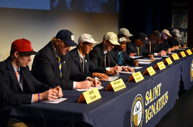 Jack Cook (left, Harvard) and William Eichenberg (second from left, Notre Dame) took part in a ceremony at St. Ignatius (Cleveland).