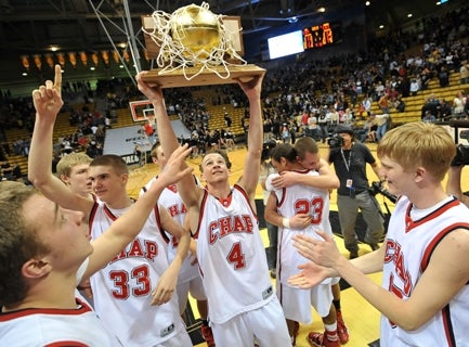 Chaparral's Josh Adams holds high the Class 5A basketball state championship trophy after its 69-67 overtime win against Arapahoe.