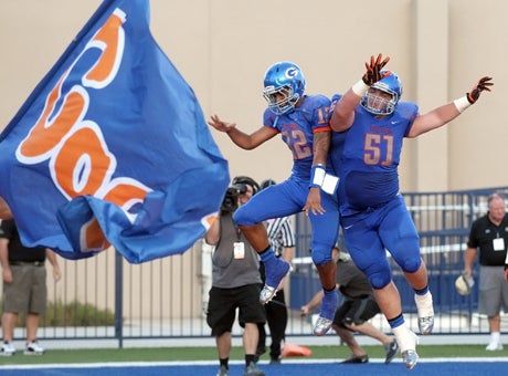 Bishop Gorman quarterback Anu Solomon (12) and Zach Singer (51) celebrate a touchdown during its 27-22 win over Good Counsel on Friday.