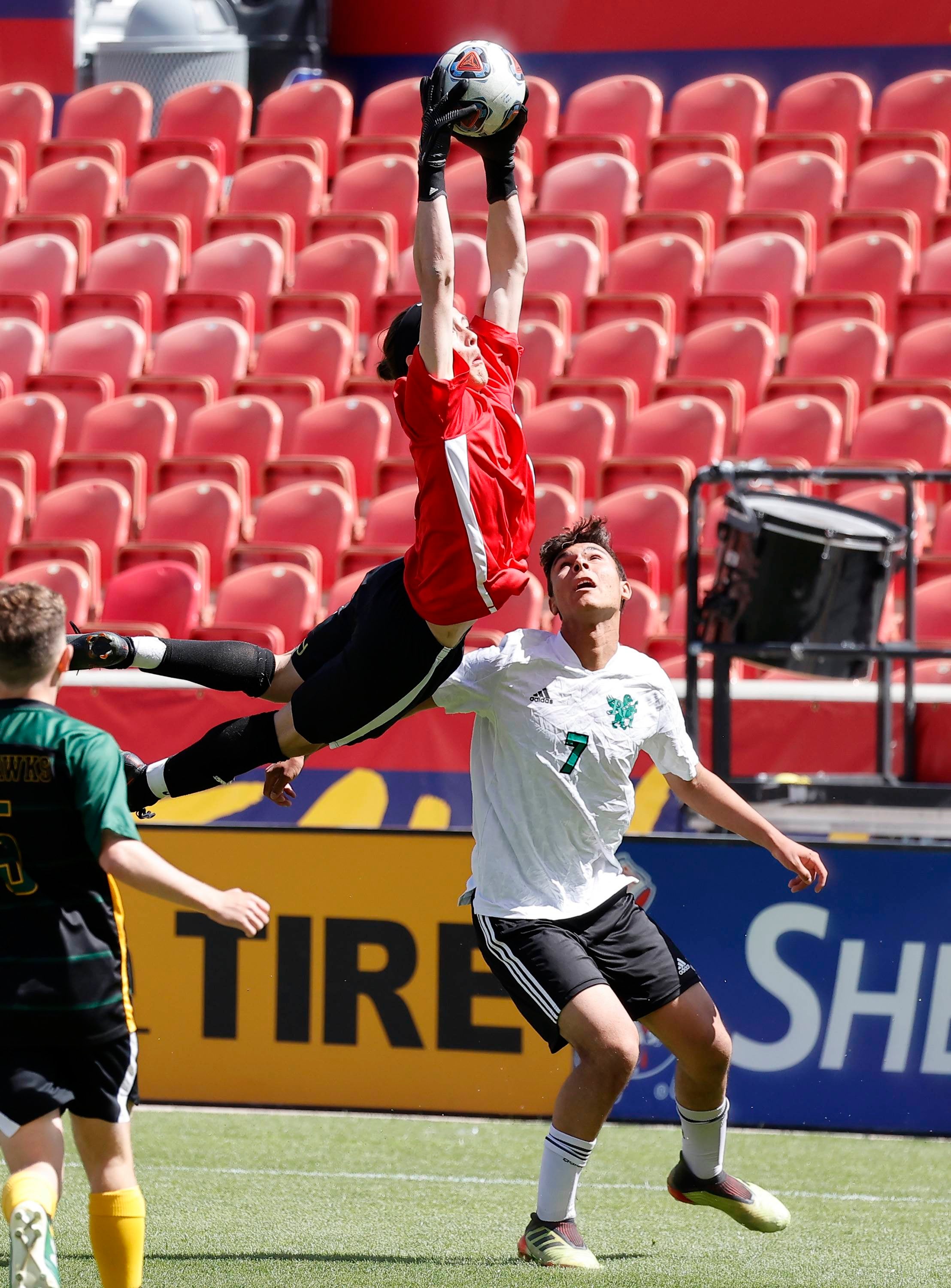 St. Joseph keeper Josh Ortiz makes a save before Rowland Hall forward River Whitten can make a play on the ball during the Utah 2A state championship match. Rowland Hall won 2-0.