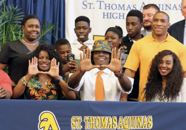 Michael Irvin Jr. of St. Thomas Aquinas (Fort Lauderdale, Fla.) and family give the universal hand signal for 'I'm gonna kick butt at the University of Miami.'