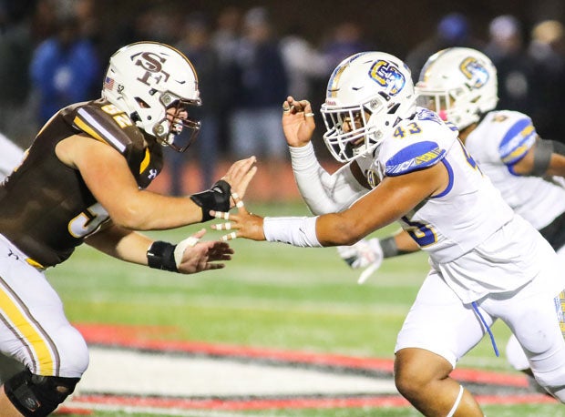 St. Francis' Oliver Bari (52) battles Serra's Ryan Mahe (43). The game was virtually even with Serra outgaining Lancers 194-193.