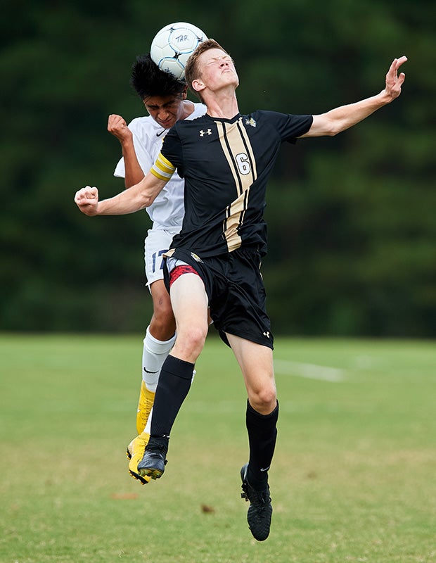 A Trinity of Durham/Chapel Hill (N.C.) player and a Trinity Academy athlete battle for a header.