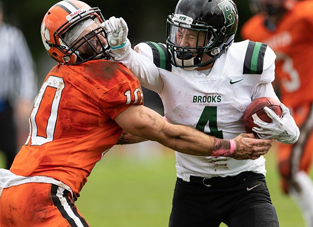Running back Ben Gill of Brooks (Mass.) stiff-arms Thayer Academy's Jack Schneider.