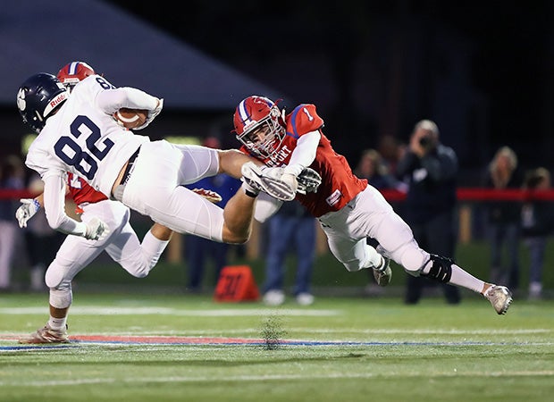 Cornerback Gavin Carlson of Fairport (N.Y.) makes a flying tackle on Pittsford's Jackson Westfall.