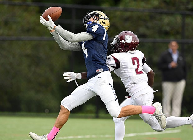 Receiver Justin Mandell of Rye Country Day (N.Y.) makes an over-the-shoulder catch ahead of defensive back Jordan Shand of Hopkins.