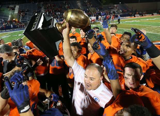 Bishop Gorman coach Tony Sanchez lifts the Sollenberger Classic trophy after his team's blowout win over Brophy College Prep.