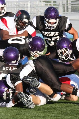 Missouri's defense swarms a Kansas ballcarrier during Thursday's 10-7 win.