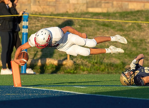 Tewksbury Memorial (Mass.) quarterback Shane Aylward dives into the end zone for a touchdown.
