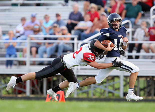 Bemidji (Minn.) quarterback Jack Larson attempts to outrun an Alexandria defender during a junior varsity game.