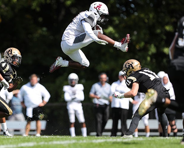A Greece Arcadia (N.Y.) player leaps to elude a Greece Athena defender.