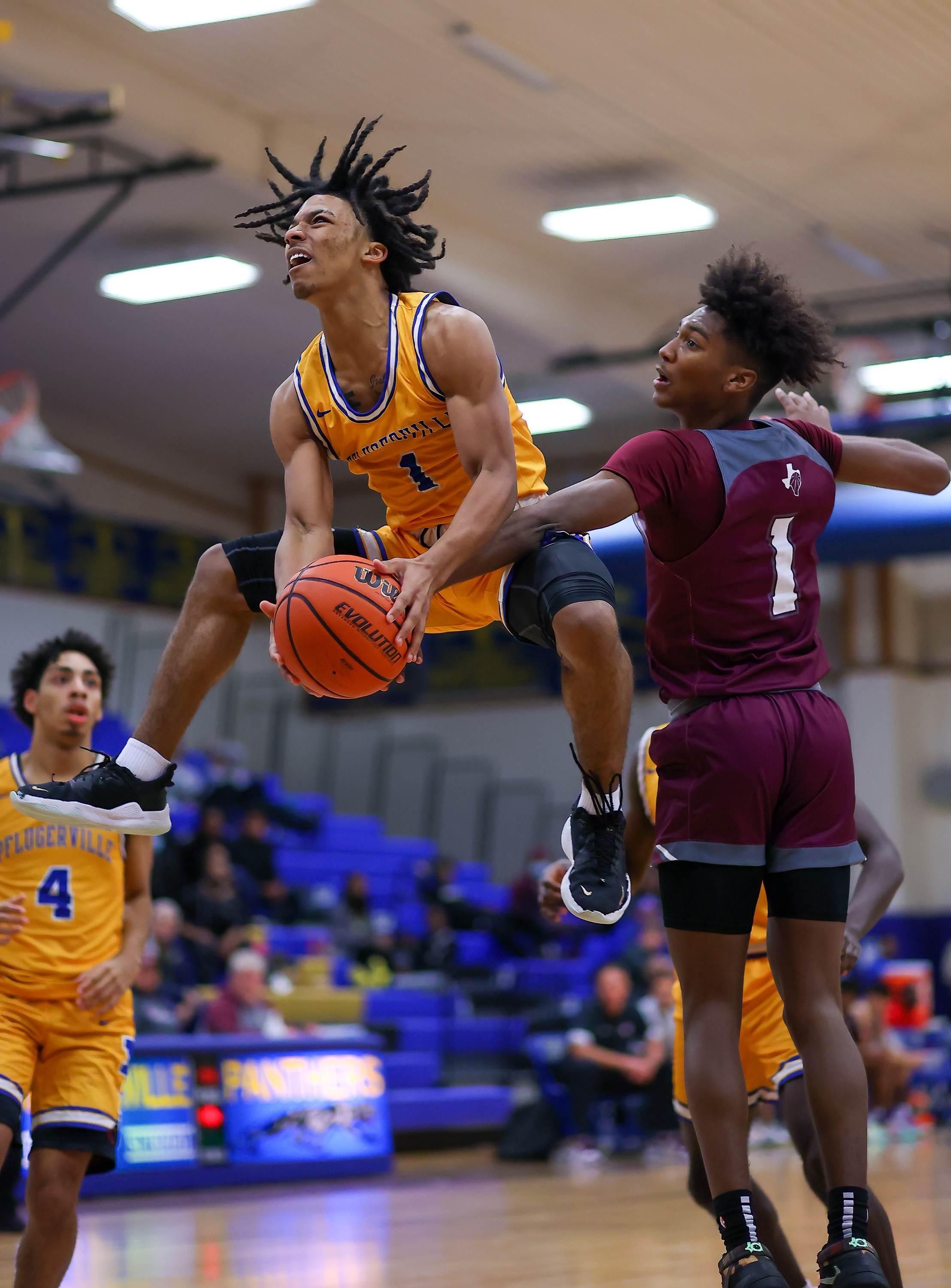Pflugerville's 5-foot-7 guard Ashten Mitchell flies to the basket past Round Rock's Jae'lyn Brooks. 