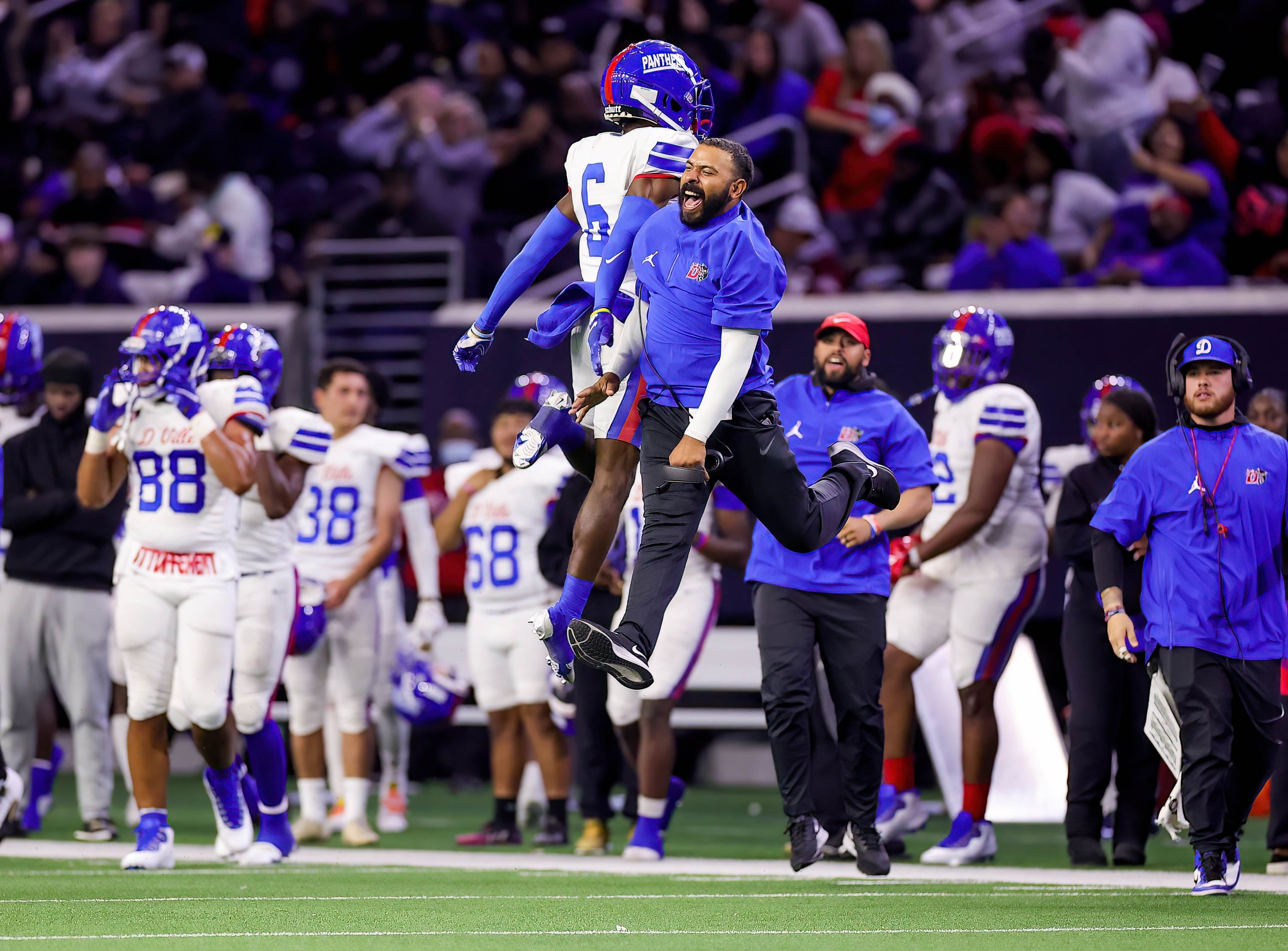 A Duncanville player and coach get major air celebrating an interception during the Panthers' 42-7 win over Spring in the UIL 6A Division 1 Regional Semifinal win. 