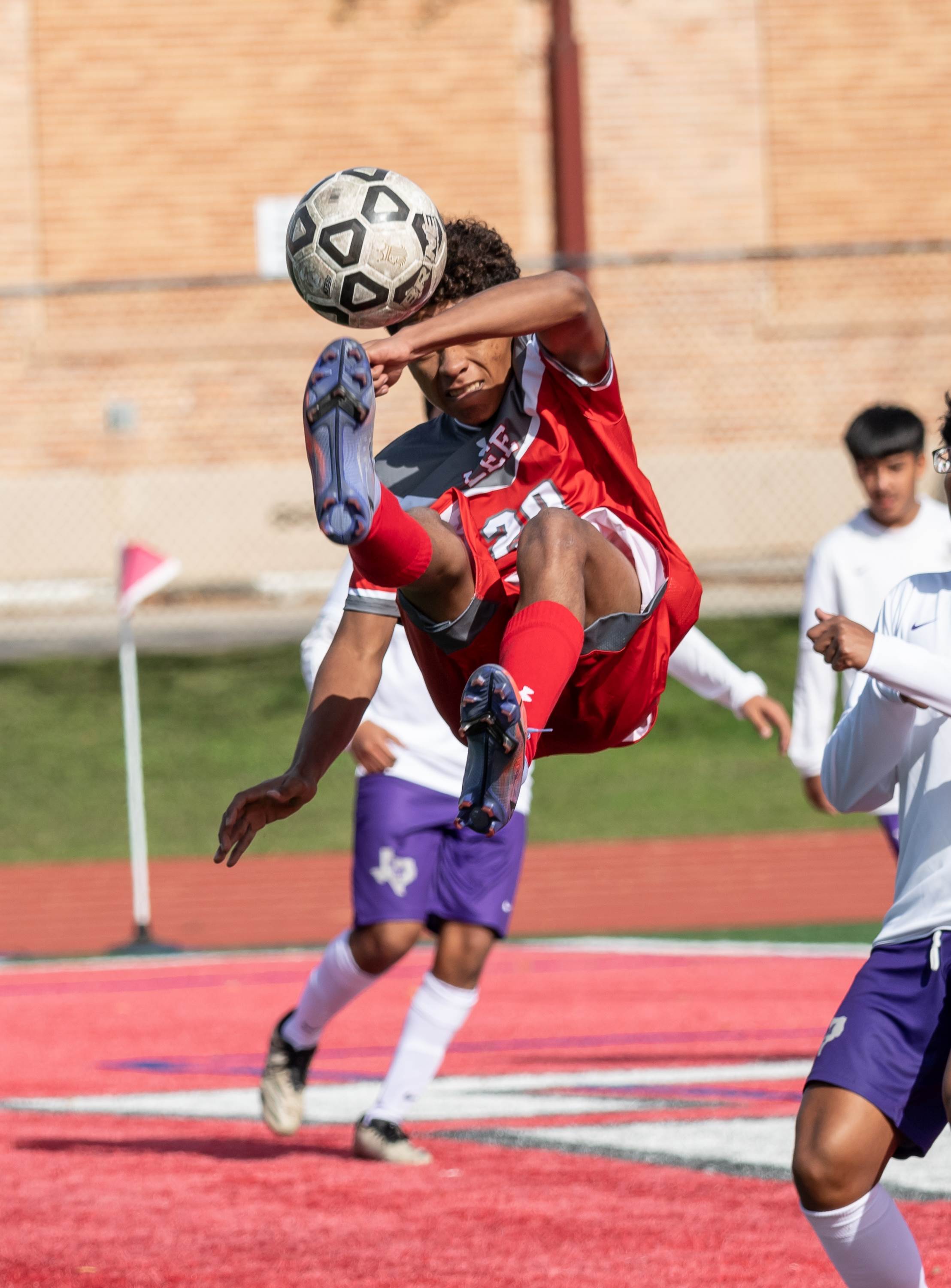 A forward for Lee, the reigning Texas 6A state champion, goes airborne for a shot on goal during a match with San Marcos.