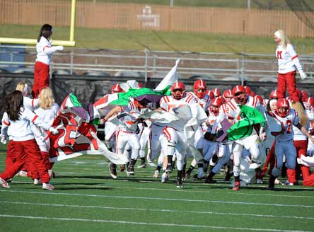 The 2008 Mount Carmel football team blasted through its team banner in this photo, while the 2011 edition blasted through the 800-win mark. Mount Carmel becomes the fifth school in the nation to net 800 wins.