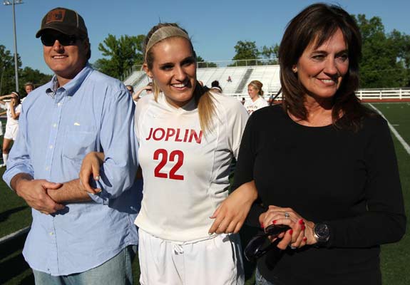 Senior athlete Kellie Stringer and her parents, Bob and Debbie, share a moment during Senior Soccer Night on May 9 at Junge Field.