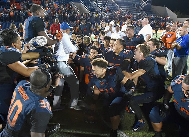 Gorman head coach Kenny Sanchez celebrates with his players following their victory over De La Salle.