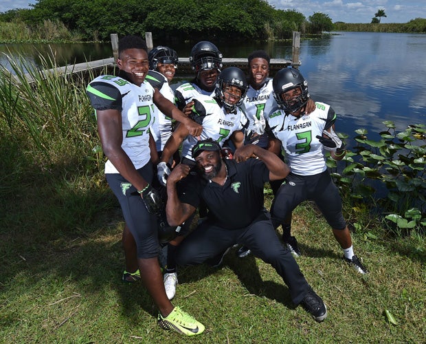 Flanagan head coach Devin Bush (kneeling) poses with six of his top players during a photo shoot at the Everglades.