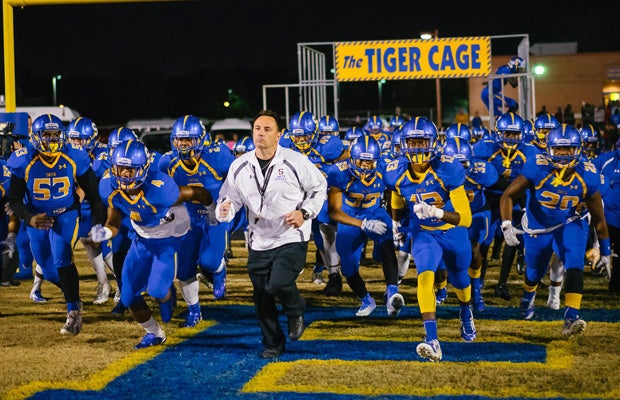 Oscar Smith head coach Richard Morgan leads his team onto the field before Friday night's 6A semifinal playoff victory over visiting Ocean Lakes.