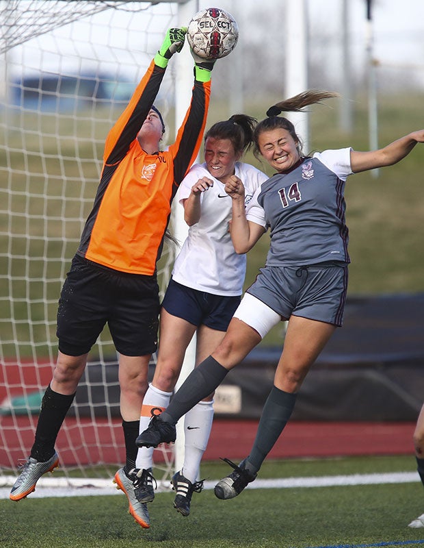 Poudre (Colo.) goalie Kaiah Mooradian swats away a corner kicker as Horizon's Amber Hurtado (far right) tries to head it in the goal.