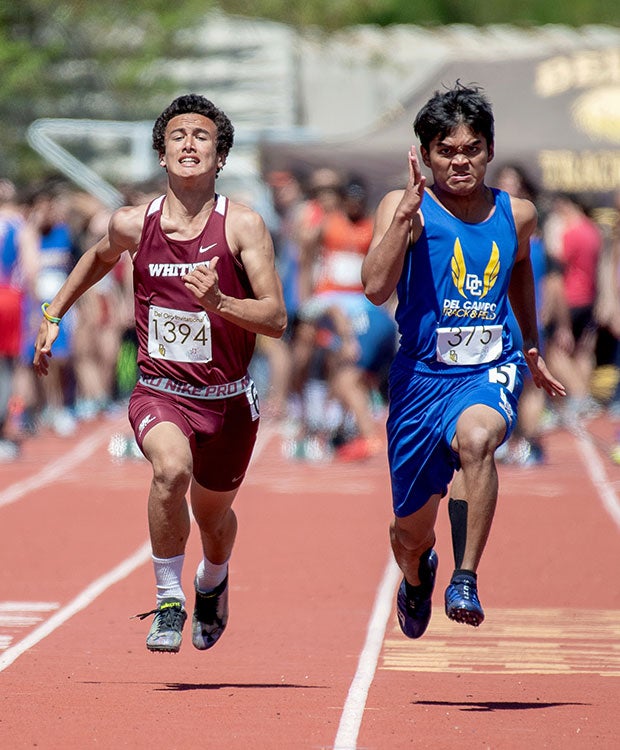A Whitney (Calif.) runner (left) and a Del Campo athlete compete in the 100 meters during the Del Oro Invitational.