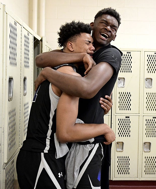 Two IMG Academy (Fla.) players celebrate in the locker room following their victory over Montverde Academy in the GEICO National Tournament semifinals in New York.