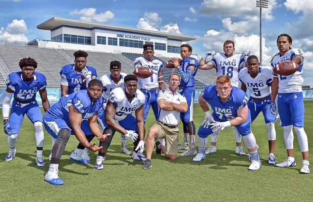 IMG Academy head coach Kevin Wright poses along with 11 top national recruits during a photo shoot at the school's football stadium in May.