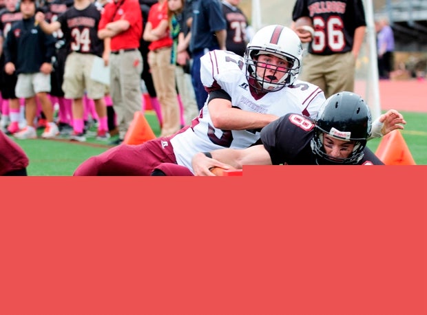 A Bedford (N.H.) player stretches for a possible touchdown while a Goffstown (N.H.) player shoves him out of bounds.