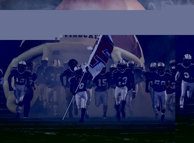 Palestine (Texas) emerges from a fog as it takes the field against Pittsburg (Texas).