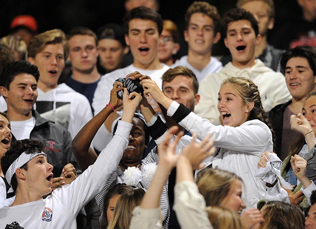 Students battle for a T-shirt thrown into the stands by the Marines during the San Clemente (Calif.) at Mission Viejo varsity football game.