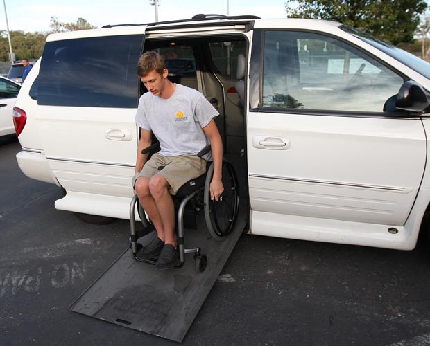 Zach Pickett wheels down the ramp of a donated custom van that is retrofitted to accommodate his disability.  